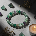 Rainbow fluorite beaded bracelet in circle showing green, purple and grey translucent beads with fluorite stones and white flowers