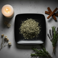 Cut and sifted dried mullein leaf on black plate with herbs, candle and flowers flat lay