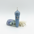 Faceted angelite crystal point wire wrapped in twisted silver with cage wrap and loop bail on light grey background