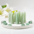 Cluster of green aventurine crystal towers on bright white background with white flowers