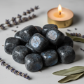 Cluster of larvikite tumbled stones with silver-blue flash and candle props