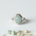 Aquamarine sterling silver V-band knot ring dominant in frame with pale icy seafoam-blue stone and ornate setting