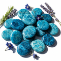 Blue Apatite flat palm stones cluster with blue flowers and candlelight